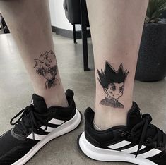 two people with tattoos on their legs and one has a black cat in the middle