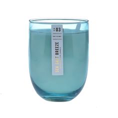 a blue glass filled with water on top of a white surface and a tag hanging from it