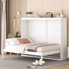 a white bed sitting on top of a wooden floor next to a wall mounted clock