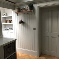 an open door in a white painted room with shelves on the wall and other items