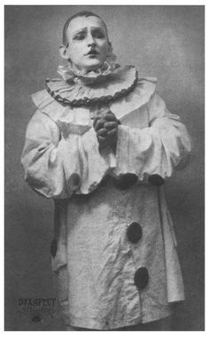 an old black and white photo of a man dressed in a clown costume with his hands on his hips