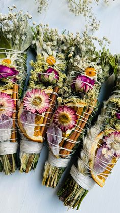 several bundles of dried flowers are wrapped in twine