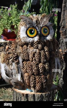 an owl sitting on top of a tree stump with large yellow eyes and brown feathers