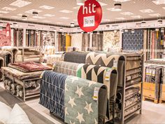 a store filled with lots of different types of furniture and rugs on display in front of a red sign