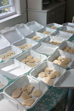 there are many trays with cookies in them on the table next to each other