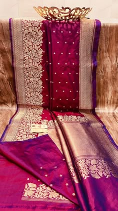 purple and pink saree with gold work on the border, sitting on a couch