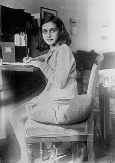 an old photo of a woman sitting at a desk with a pen in her hand