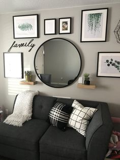 a living room filled with furniture and framed pictures on the wall above it's mirror