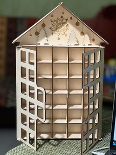 a laptop computer sitting on top of a table next to a doll house with shelves