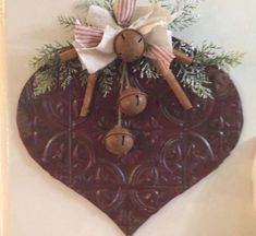 a wooden heart with bells hanging from it's side