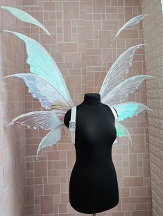 a mannequin wearing a black dress with white wings