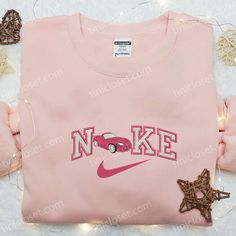 Introducing our Pink Car x Nike Embroidered Shirt – a perfect blend of street style and sporty vibes. Made with premium quality fabric, this shirt features a vibrant pink car embroidery on the chest, adding a unique touch to your outfit. The iconic Nike logo on the sleeve adds a touch of athleisure. With its comfortable fit and trendy design, this shirt is perfect for any casual occasion. Stand out from the crowd and express your individuality with this statement piece. Elevate your street Nike Cartoon, Troy Trojans, Nike Inspired, Embroidered Apparel, Maroon Hoodie, Cat Valentine, Sports Hoodies, Hoodie Material, Custom Nikes