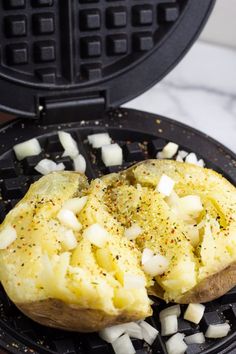 an open waffle iron with potatoes and onions on it