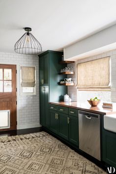 a kitchen with green cabinets and a rug on the floor