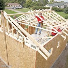 two men standing on the roof of a house under construction