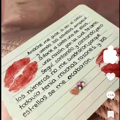 a note with red lipstick on it next to a cell phone and an earring