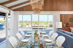 the dining room table is set with place settings for eight people and has glass doors leading to an outdoor deck