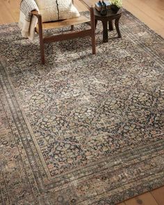 a living room with a large rug on the floor next to a chair and coffee table