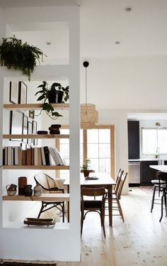 a room filled with furniture and lots of bookshelves next to a dining table