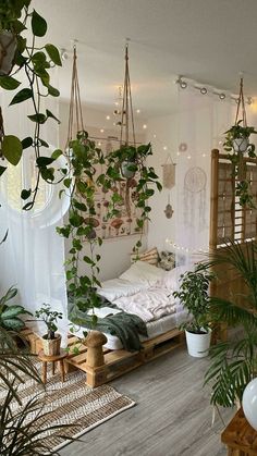 a room filled with lots of plants next to a bed