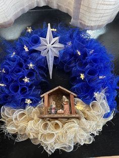 a christmas wreath with a nativity scene on it and a star hanging from the top