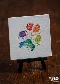 a small easel sitting on top of a wooden table