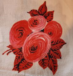 an embroidered piece of cloth with red flowers on it