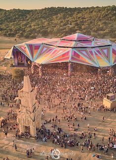 an aerial view of a large group of people gathered in front of a colorful structure