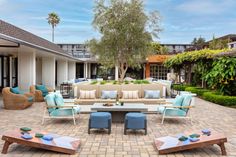 an outdoor living area with couches, tables and chairs in the middle of it