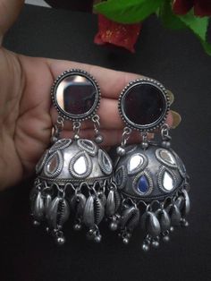 Silver jewelry has always been a great companion for white ethnics, and we are sure our Mirror Silver Oxidised gungroo jhumkis is all you will need to complete your looks. Appealing pair of earrings dressed with dreamy gungroo by the edge of jhumki dome and intricate floral detailing. A funky pair of earrings that adds a story to your look. Silver Earrings With Bells For Festivals, Silver Bell Earrings For Festivals, Silver Jhumkas For Navratri, Festive Silver Jewelry With Bells, Oxidized Finish Jhumkas For Gift, Metal Jhumkas For Navratri Celebration, Gift Oxidized Finish Jhumkas, Navratri Celebration Metal Jhumkas, Handmade Metal Chandbali Jhumkas