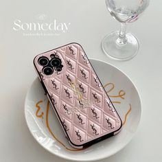 a pink case with an image of two birds on it and some wine glasses in the background