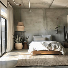 a bed sitting in a bedroom next to a window with plants on the side of it