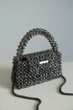 Whether you're attending a glamorous gala, a romantic dinner, or a chic cocktail party, this beaded bag is the perfect accessory to complement your attire. It effortlessly transitions from a dazzling statement piece to a timeless classic, making it a versatile addition to your collection. Beaded Top Handle Evening Bag, Silver Beaded Rectangular Bag, Silver Beaded Pouch Evening Bag, Beaded Evening Shoulder Bag With Top Handle, Beaded Top Handle Evening Shoulder Bag, Evening Beaded Top Handle Shoulder Bag, Beaded Top Handle Shoulder Bag For Evening, Evening Top Handle Bag With Beaded Details, Silver Embellished Bags For Party