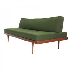 a green couch sitting on top of a wooden frame