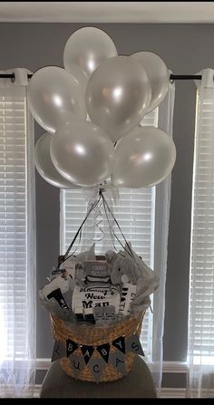 a basket filled with white balloons sitting on top of a table