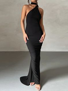 a woman in a black dress posing for the camera with her hands on her hips