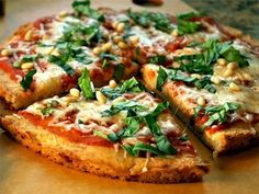 a pizza sitting on top of a cutting board covered in cheese and spinach leaves