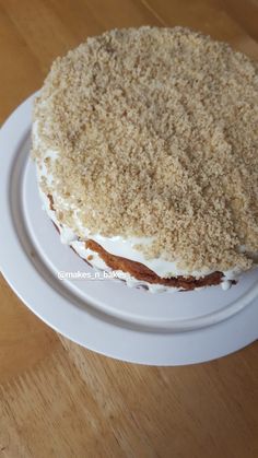 a cake with white frosting and crumbs sitting on top of a plate