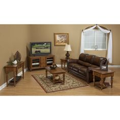 a living room filled with furniture and a flat screen tv on top of a wooden table