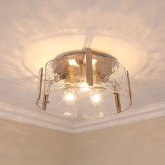 a light fixture in the corner of a room with white walls and ceiling lights on it