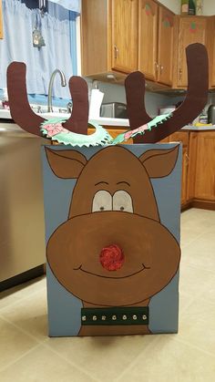 a cardboard box with a reindeer face on it's side in the middle of a kitchen