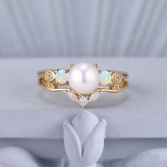 an opal and diamond ring sits on a white surface