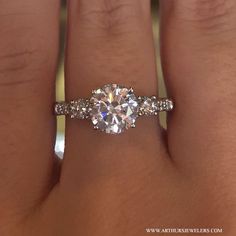 a woman's hand with a diamond ring on top of her finger and an engagement band