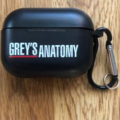 an airpods case with the words grey's anatomy on it sitting on a wooden surface