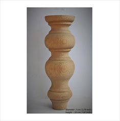 a tall wooden vase sitting on top of a table