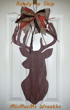 a door hanger with a deer head and bow on it that says ready to ship