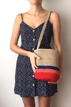 a woman in a dress holding a straw bag