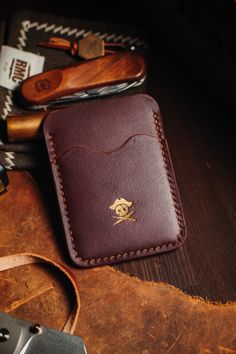 a leather wallet sitting on top of a table next to other tools and knives,