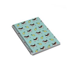 a spiral notebook with a pattern of dogs and lemons on the front, in light blue