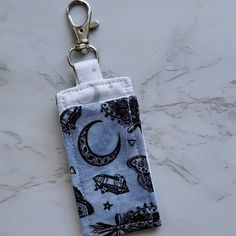 a cell phone case with a keychain hanging from it's side on a marble surface